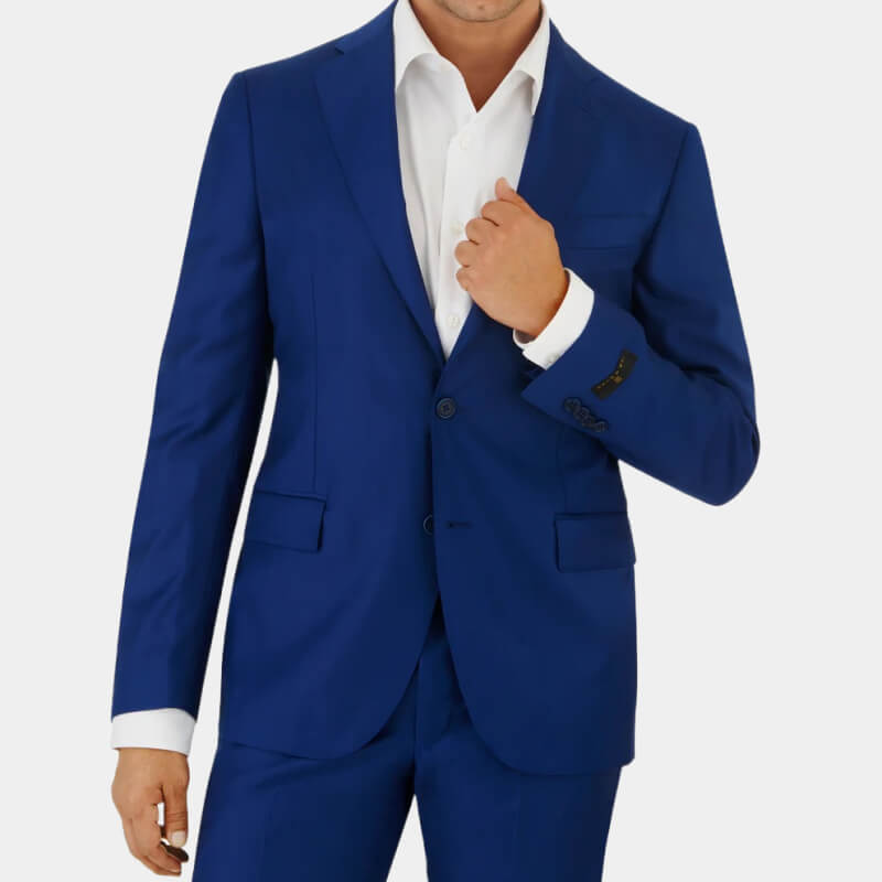 Model wearing dark blue Ike Behar suit against pale gray background 