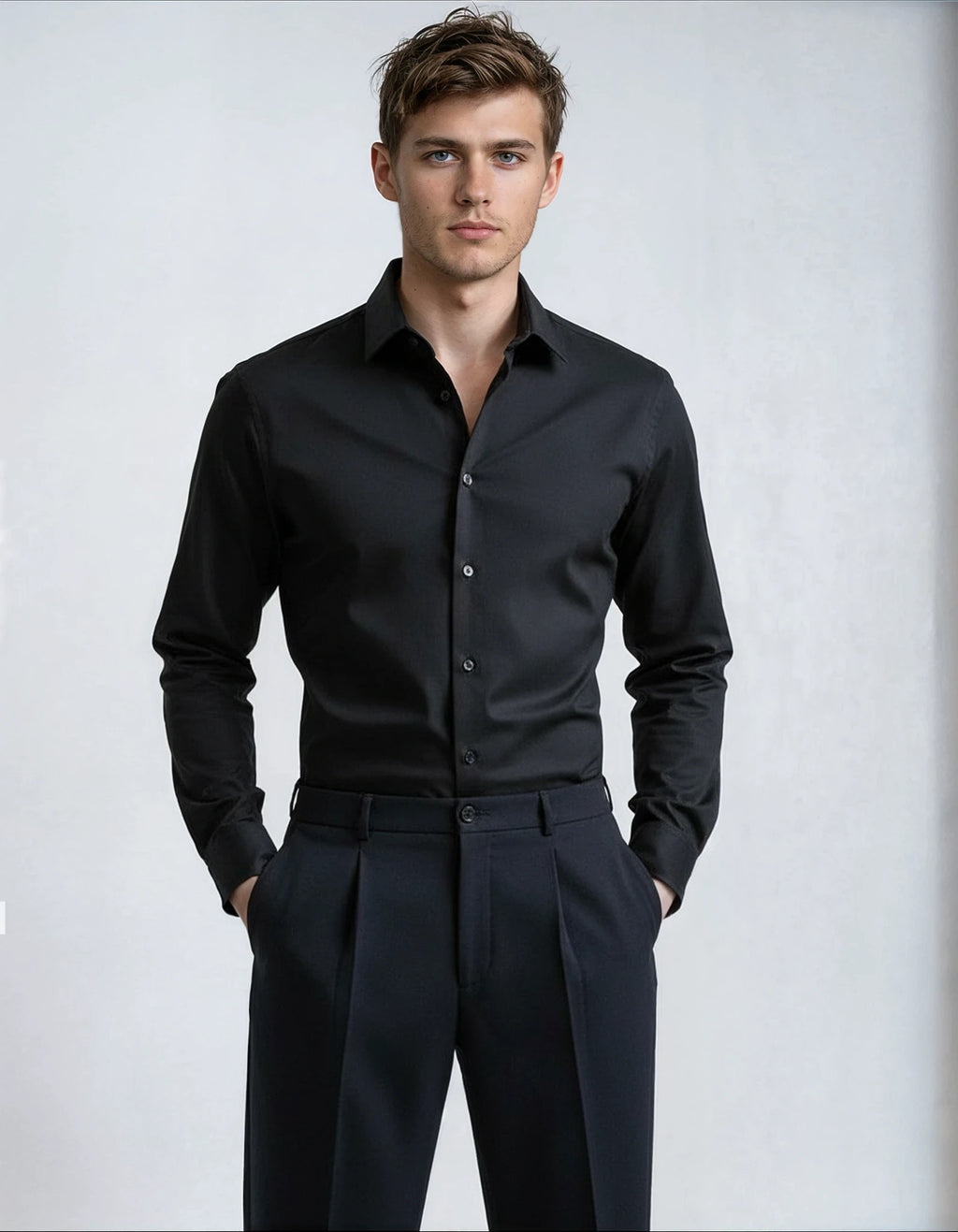 Man wearing a black dress shirt and pants on a light gray background