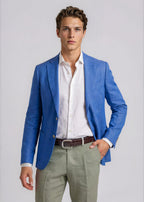 Man wearing a blue blazer, white shirt, and green pants on a light gray background