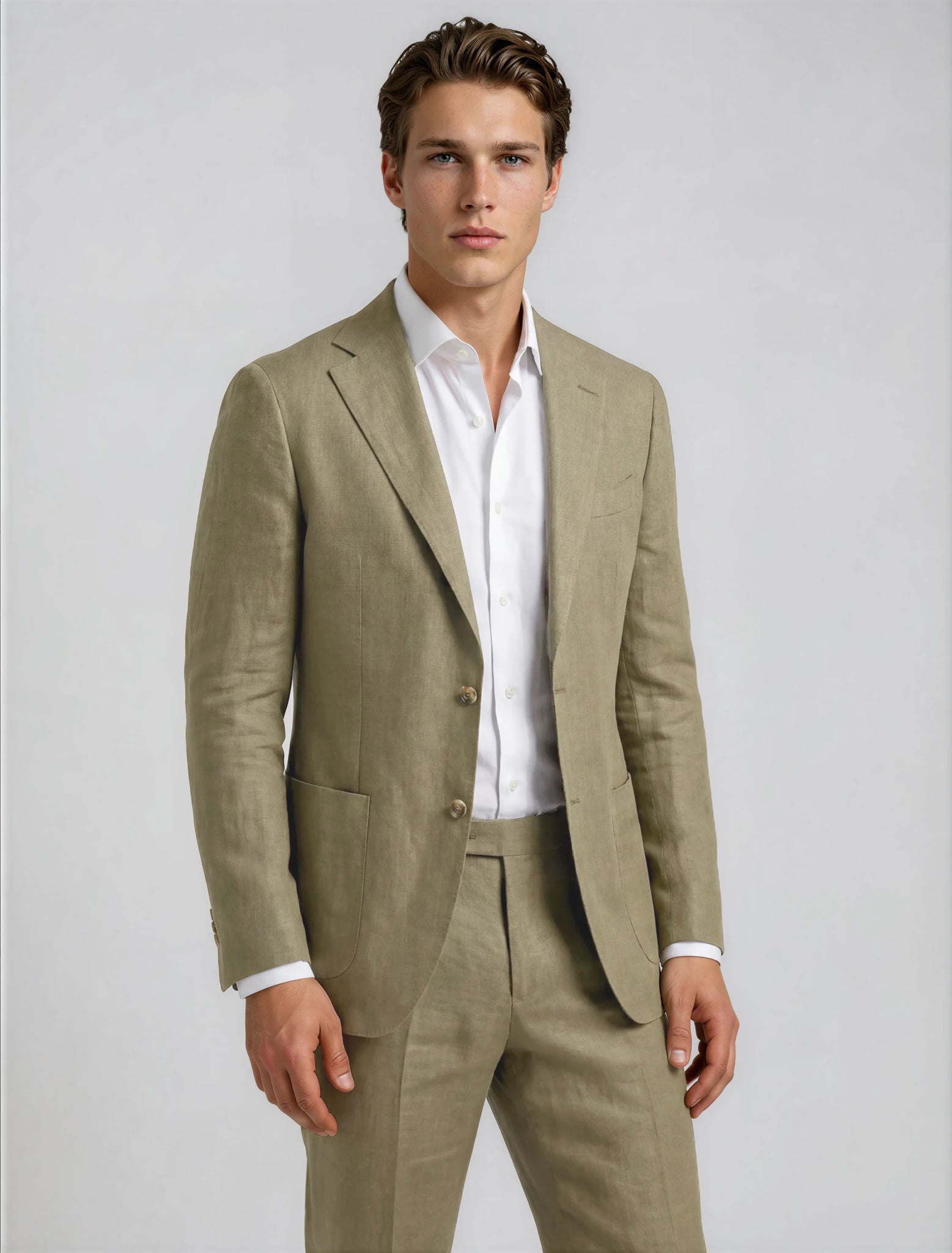 Man wearing a light brown suit with a white shirt on a plain background