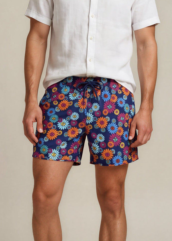 Man wearing a white shirt and colorful floral shorts on a beige background