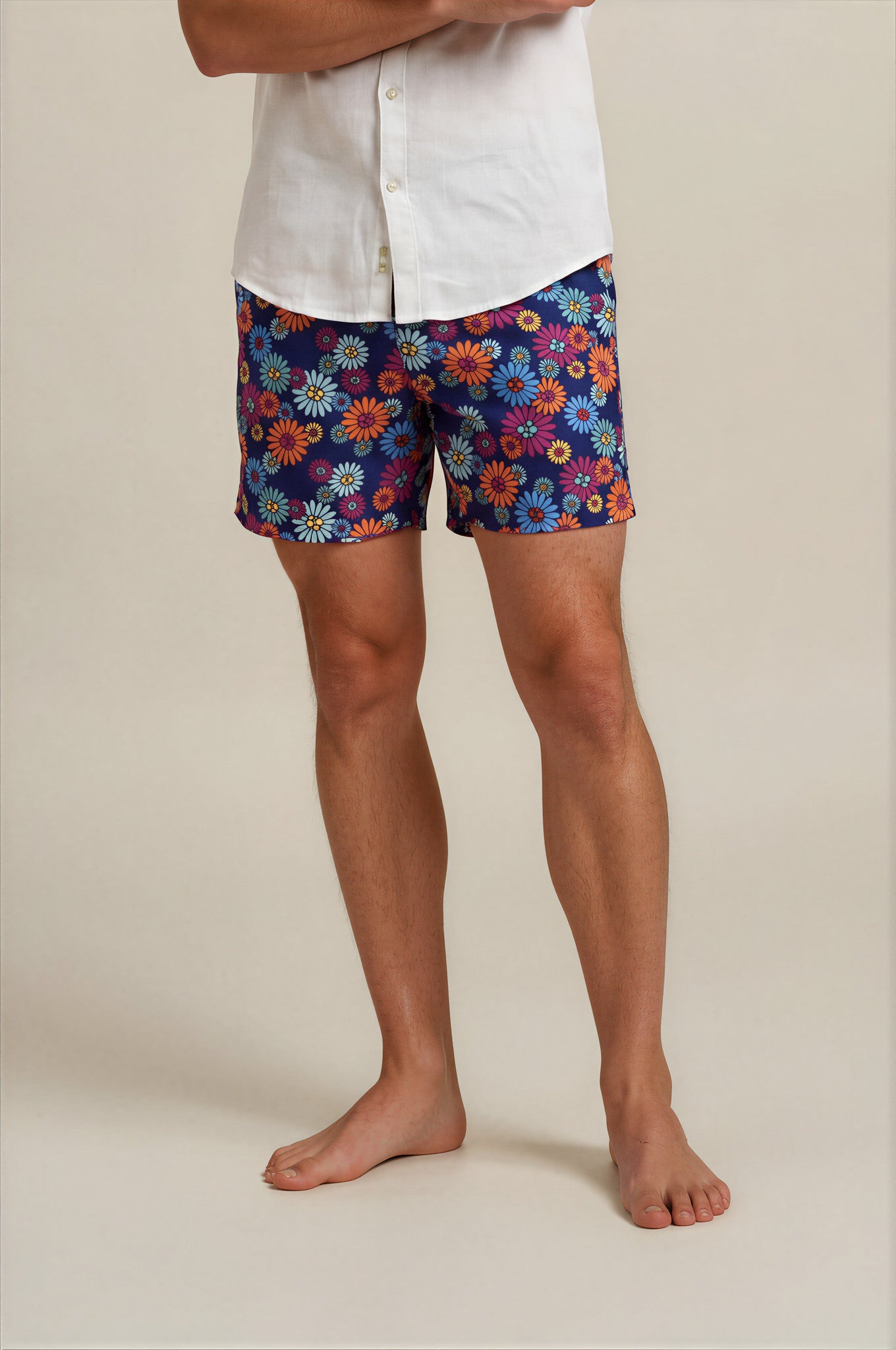 Person wearing colorful floral shorts on a plain background