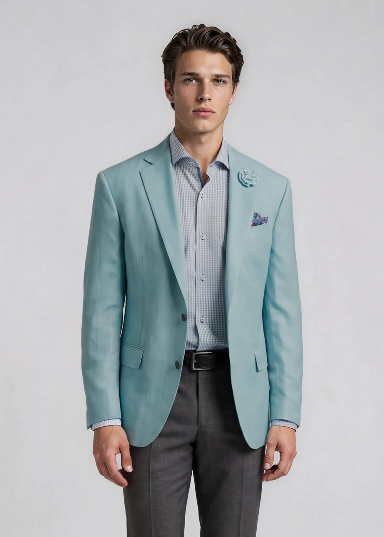 Man wearing a light blue blazer, gray pants, and a striped shirt on a plain background