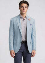 Man wearing a light blue blazer over a striped shirt with a white background