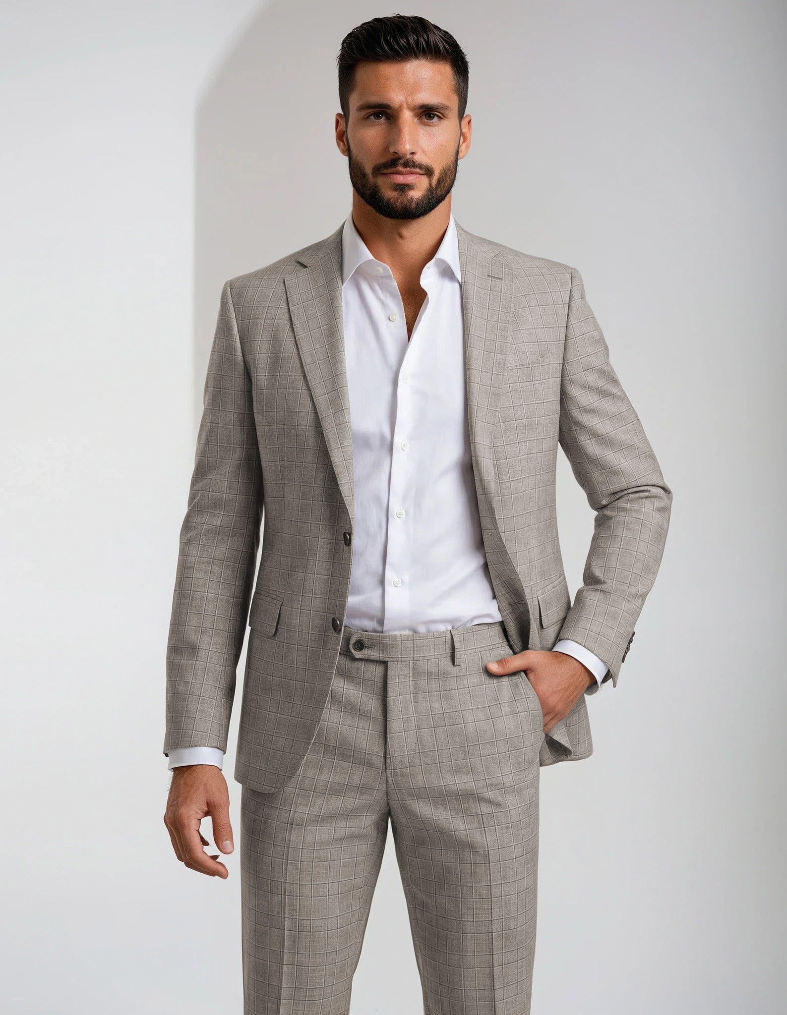 Man wearing a gray/brown glen plaid suit on a plain background