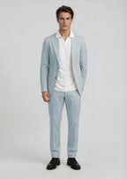 Man wearing a light gray suit with a white shirt on a plain background