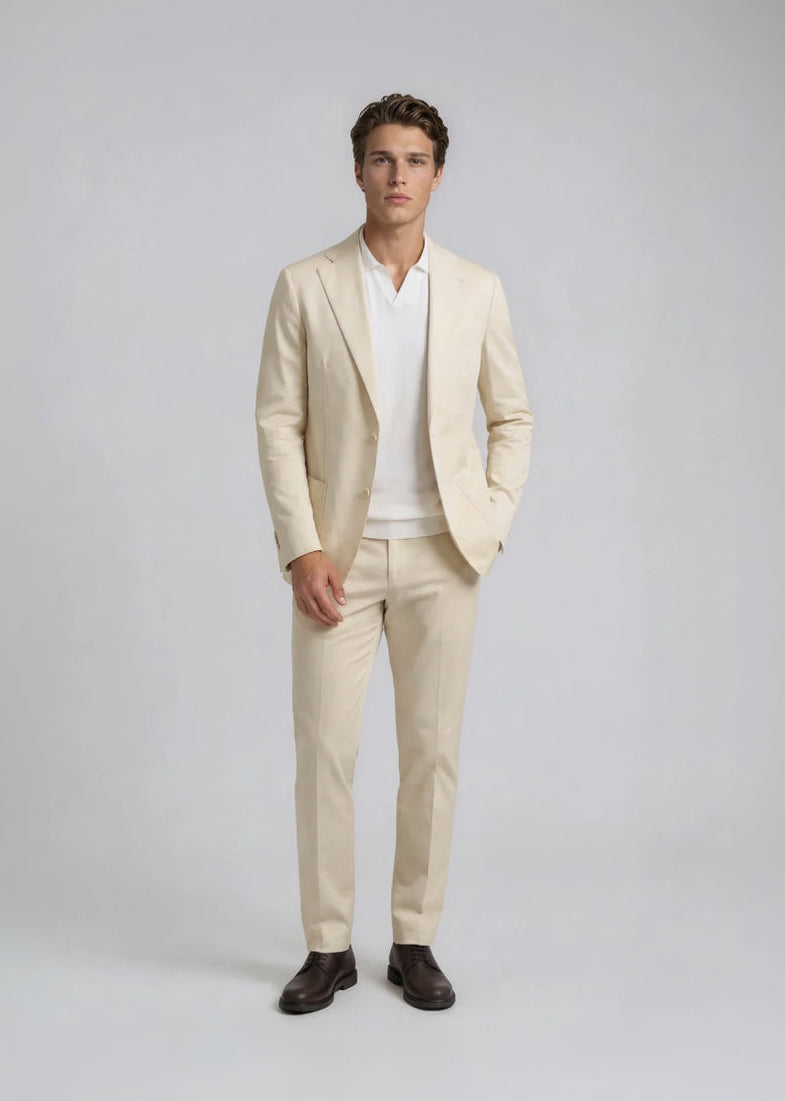 Man wearing a beige suit with a white shirt on a gray background