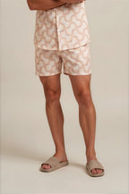 Person wearing beige shorts with a geometric pattern on a plain background