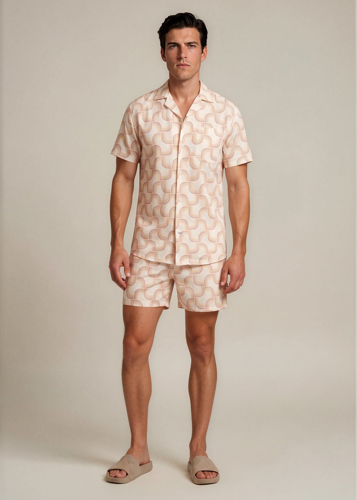 Man wearing a matching shirt and shorts set with a light pattern on a plain background