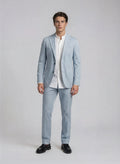 Man wearing a light blue suit with a white shirt on a plain background