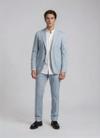 Man wearing a light blue suit with a white shirt on a plain background